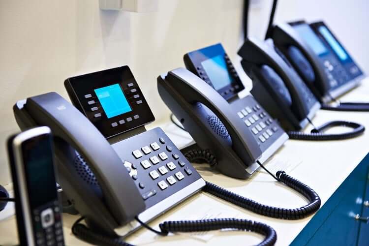 Office phones lined up on a desk