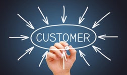 Hand drawing arrows pointing to the word customer, emphasising the importance of strategic CRM goals