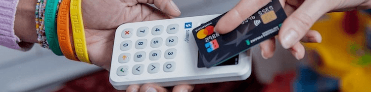 Woman taking payment with a SumUp card reader