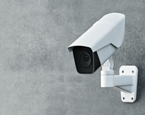 White security camera mounted on grey wall featured image