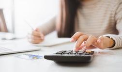 Woman working out costs on a calculator