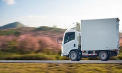 Side-on picture of Trailer Truck moving along a highway