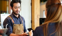 A man takes a payment in a store.
