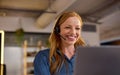 Femme souriante passant un appel depuis un micro-casque.