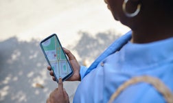 woman with phone in hand tracking vehicle using her phone