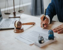 Vehicle tracking legal documents on table with gavel and toy car