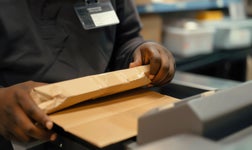 A person uses a postage meter.