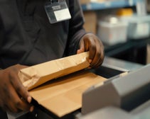 A person uses a postage meter.