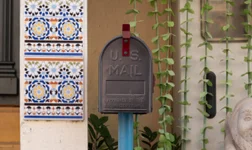 US Mail box in front of a house with tiled walls