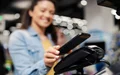 Close up of a woman paying bill on pos terminal with her phone at supermarket.
