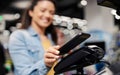 Close up of a woman paying bill on pos terminal with her phone at supermarket.