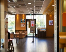 Inside of a McDonald's featuring a self-service kiosk