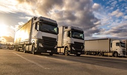 three trucks in a line with the sunset in the background