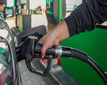 person holding pump and filling up their vehicle with gas