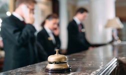 Out of focus picture of hotel employees answering phone at reception