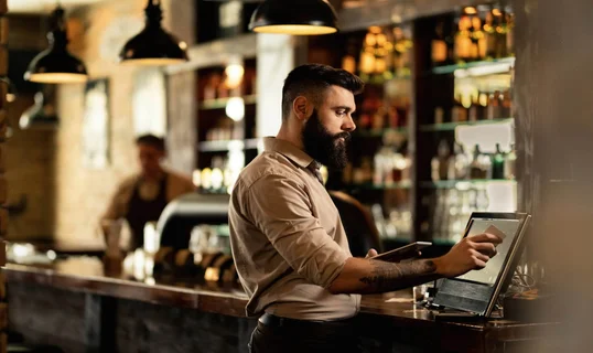 Bar tender operating a register/till POS system