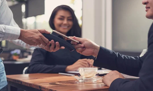 Man paying for meal at restaurant using digital wallet on phone