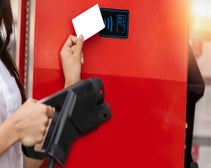 person holding EV pump and a fuel card for contactless payment at gas station