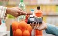 Person paying for their shopping at the supermarket using a POS card machine which accounts for POS system costs
