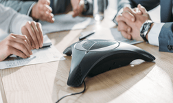 conference phone surrounded workers out of shot