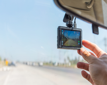 close up angle of a person positioning a dashcam in a car, van or truck while on a highway