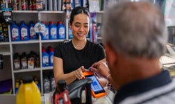Une caissiere utilisant un TPE pour une transaction carte sans contact