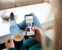 Close up of woman shopping for clothes online using smartphone