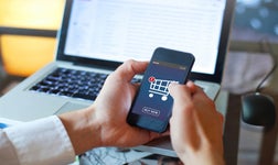 Hands holding smartphone shopping online best ecommerce platforms for small businesses