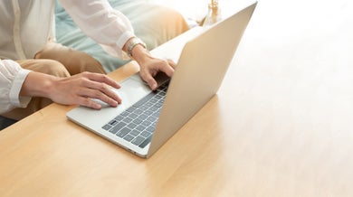 Hands typing on laptop