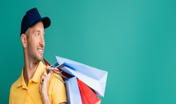 Man holding shopping bags on green background