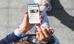 person scrolling through a social media feed on a mobile phone