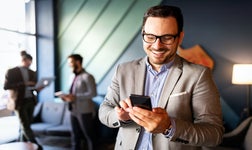 smiling man taps smartphone
