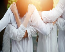 back view of young people linking arms