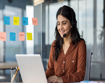 women with headset calling via her ucaas phone system on laptop