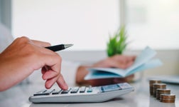 Typing on a calculator near coins