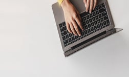 Woman's hands typing on laptop