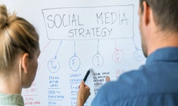 two people viewing a whiteboard with a content strategy for social media on it