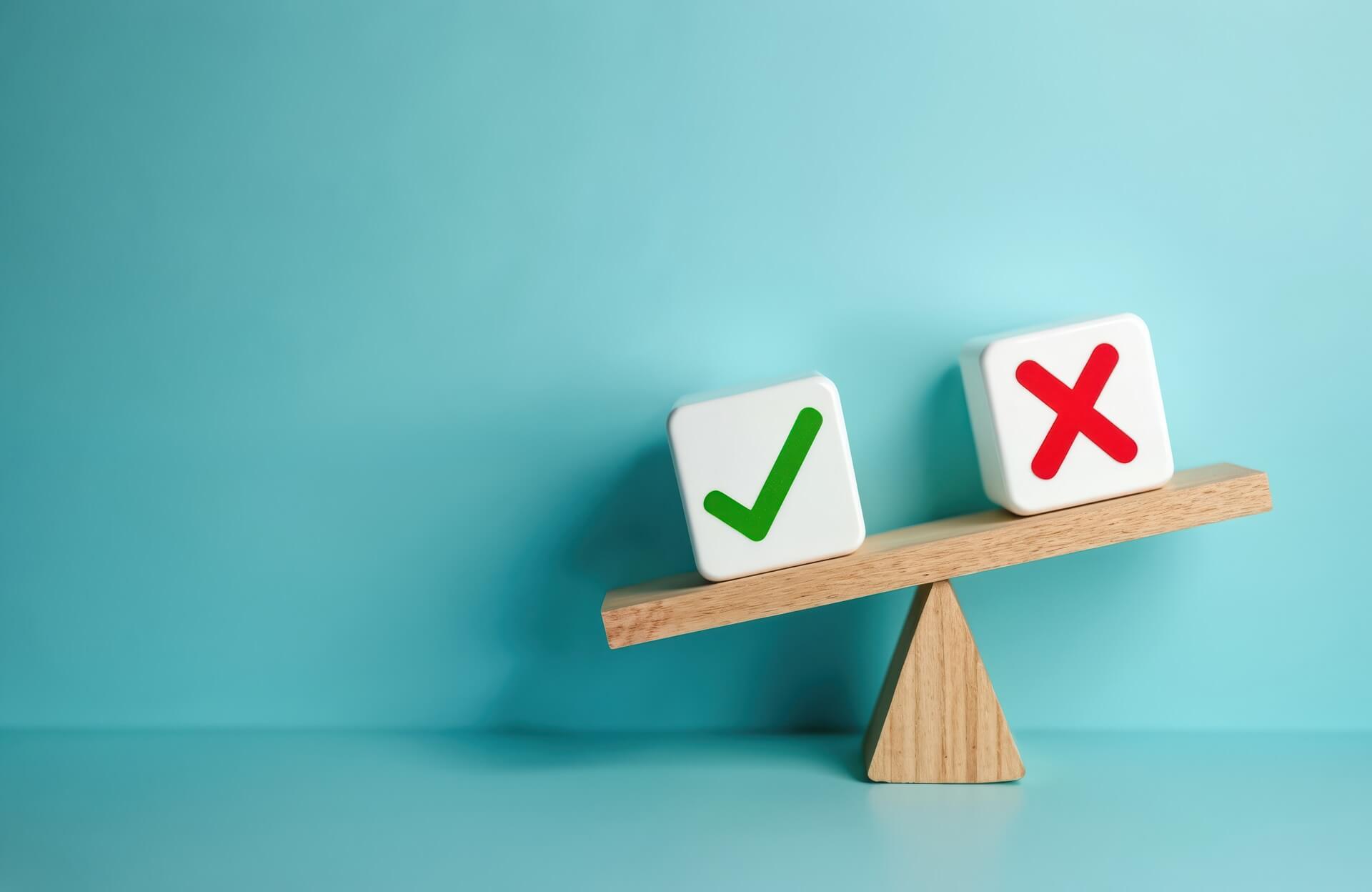 Wooden scale with positive check mark, negative cross mark.