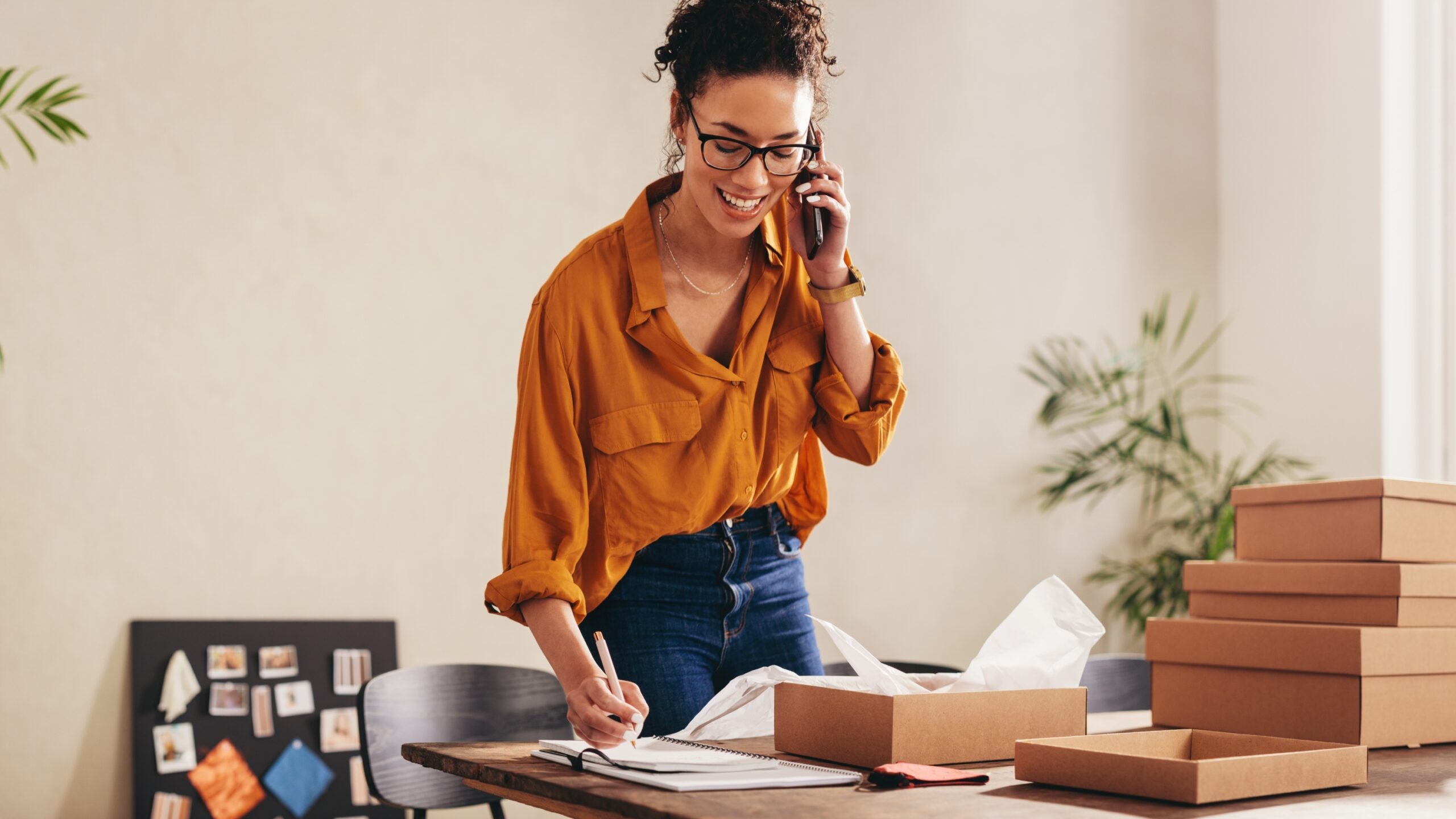 woman on the phone in her office surrounded by boxes to unpack and set up office