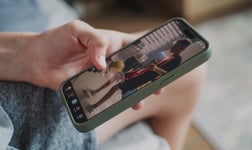 hand scrolling on TikTok app videos using their smartphone