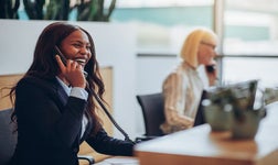 Laughing businesswoman answering at an office reception desk