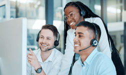 A manager trains two employees with headsets on.