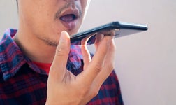 man holding phone to his mouth with mouth open