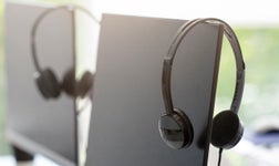 headsets hanging on display screen monitors for VoIP calling