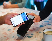 A person making a payment at a cafe using a mobile wallet