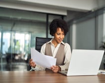 Professional business woman account manager executive checking document financial report using laptop