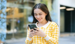 woman using smartphone outdoors, messaging or browsing