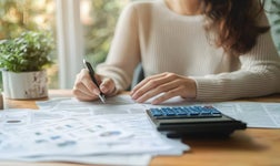 Woman using calculator in home office
