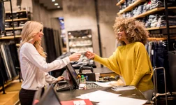 woman customer paying with credit card in fashion showroom