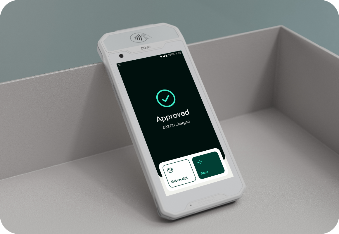 Dojo Go card machine on a table with two hands around it